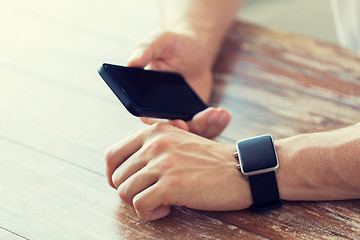 Image showing close up of hands with smart phone and watch