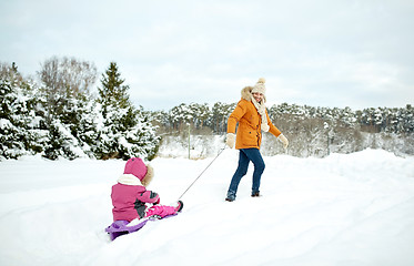 Image showing happy father pulling sled with child in winter