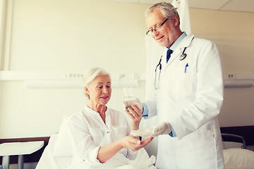 Image showing doctor giving medicine to senior woman at hospital