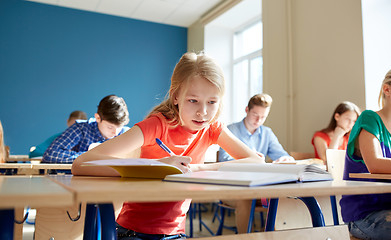 Image showing student girl with book writing school test