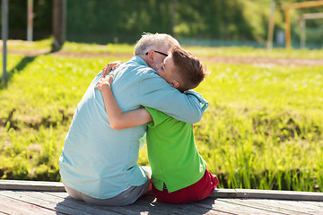 Image showing grandfather and grandson hugging on berth