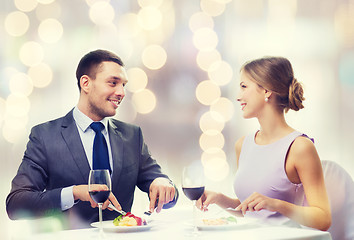 Image showing smiling couple eating main course at restaurant