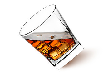 Image showing Whiskey with ice in a tilted glass