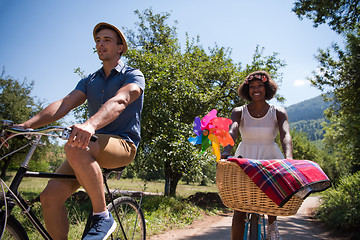 Image showing Young multiethnic couple having a bike ride in nature