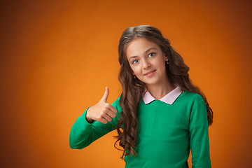 Image showing The cute cheerful little girl on orange background