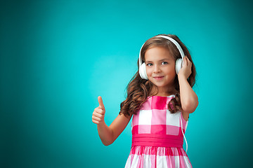 Image showing The cute cheerful little girl on orange background