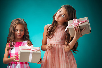 Image showing The two cute cheerful little girls on blue background