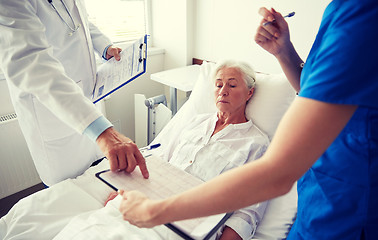 Image showing doctor and nurse visiting senior woman at hospital