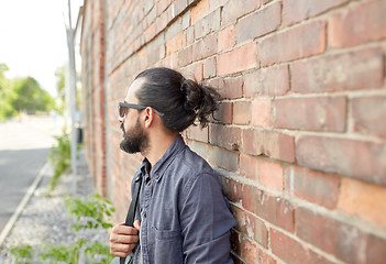 Image showing man with backpack standing at city street wall