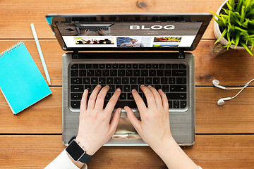 Image showing close up of woman blogging on laptop