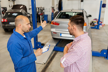 Image showing auto mechanic with clipboard and man at car shop