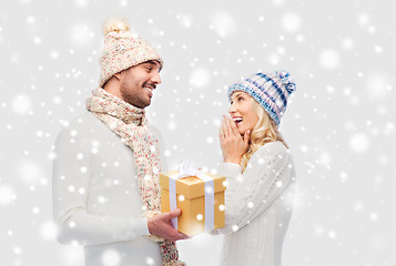 Image showing smiling couple in winter clothes with gift box