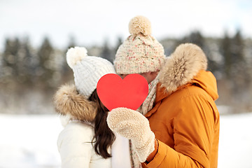 Image showing happy couple with red heart over winter landscape
