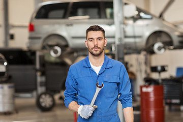 Image showing auto mechanic or smith with wrench at car workshop