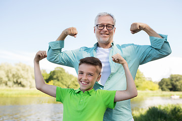 Image showing happy grandfather and grandson showing muscles