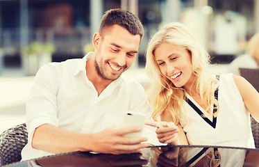 Image showing happy couple with smatphone at city street cafe