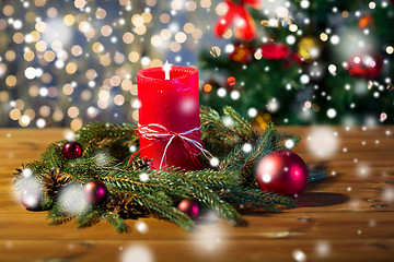 Image showing fir branch wreath with candle on wooden table