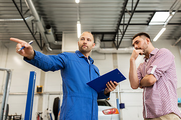 Image showing auto mechanic with clipboard and man at car shop