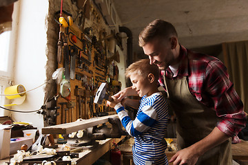 Image showing father and son with hammer working at workshop