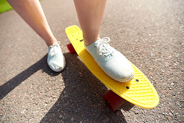 Image showing close up of female feet riding short skateboard