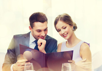 Image showing smiling couple with menu at restaurant