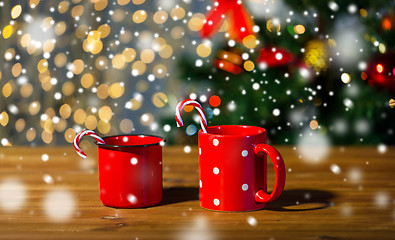 Image showing christmas candy canes and cups on wooden table