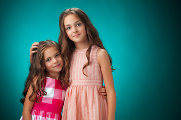 Image showing The two cheerful little girls on orange background