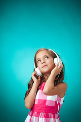 Image showing The cute cheerful little girl on orange background