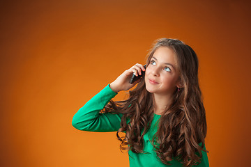 Image showing The cute cheerful little girl on orange background