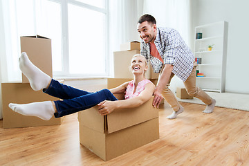 Image showing couple with cardboard boxes having fun at new home