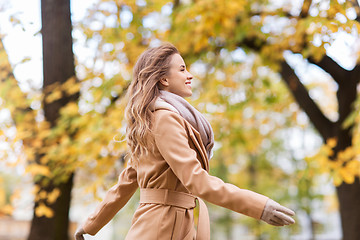 Image showing beautiful happy young woman walking in autumn park