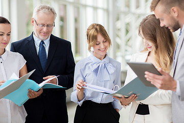 Image showing business team with tablet pc and folders at office