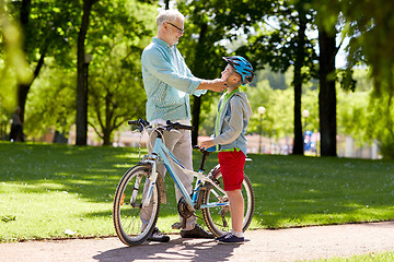 Image showing grandfather and boy with bicycle at summer park