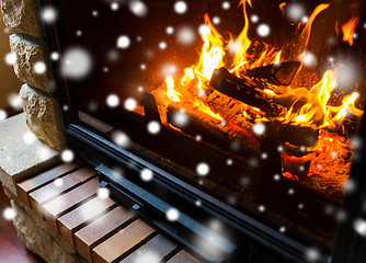 Image showing close up of burning fireplace with snow