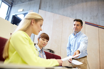 Image showing teacher giving exam tests to students at lecture