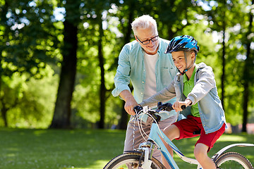 Image showing grandfather and boy with bicycle at summer park