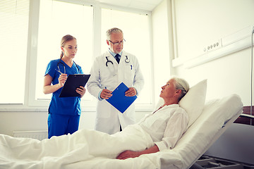 Image showing doctor and nurse visiting senior woman at hospital