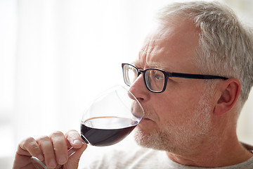 Image showing close up of senior man drinking wine from glass