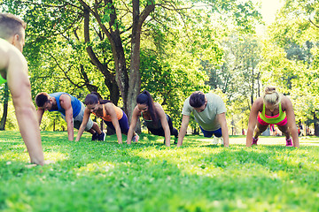 Image showing group of friends or sportsmen exercising outdoors