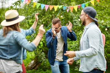 Image showing happy friends dancing at summer party in garden