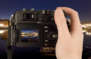 Image showing Digital Camera photo in a hand isolated on withe background. lcd screen and background can be easily edited