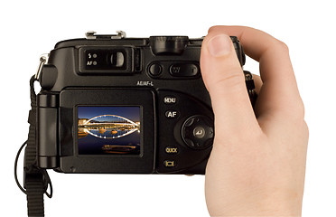 Image showing Digital Camera photo in a hand isolated on withe background. lcd screen and background can be easily edited