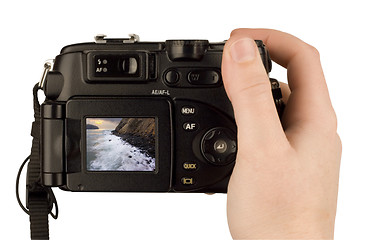 Image showing Digital Camera photo in a hand isolated on withe background. lcd screen and background can be easily edited