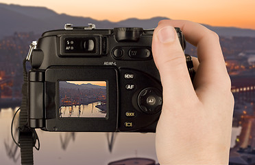 Image showing Digital Camera photo in a hand isolated on withe background. lcd screen and background can be easily edited