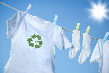 Image showing T-shirt with recycle logo drying on clothesline on a hot summer day