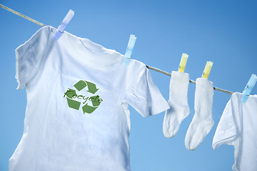 Image showing T-shirt with recycle logo drying on clothesline on a  summer day