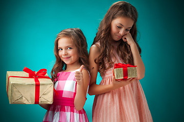 Image showing The two cute cheerful little girls on blue background