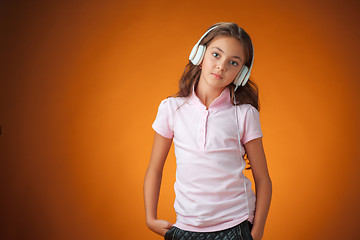 Image showing The cute cheerful little girl on orange background