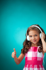 Image showing The cute cheerful little girl on orange background