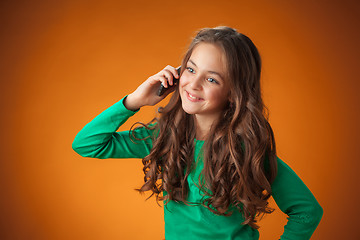 Image showing The cute cheerful little girl on orange background